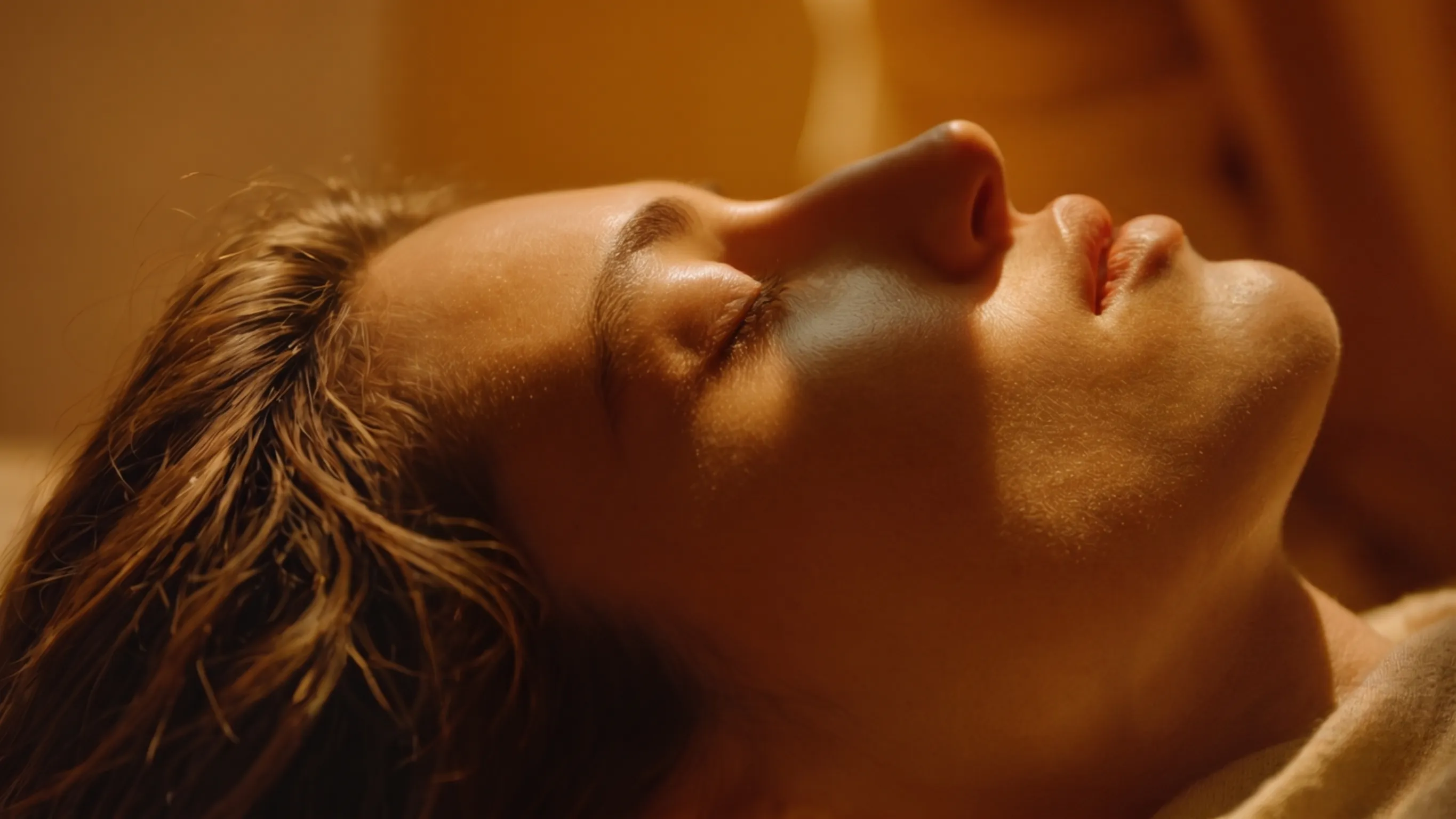 A face in repose, breath deepening, a quiet hand at the edge